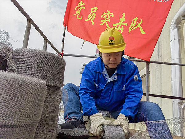 5月10日中午，在動力車間三期工藝除氧器平臺上，黨員突擊隊隊長李鑫正在纏繞新填料.jpg