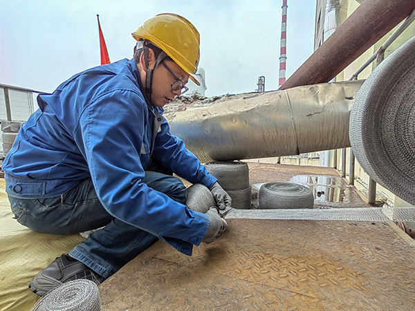 5月10日中午，在動力車間三期工藝除氧器平臺上，黨員突擊隊隊員劉瑞斌正在纏繞新填料.jpg